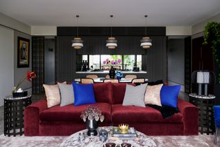 an open living room kitchen with a red sofa
