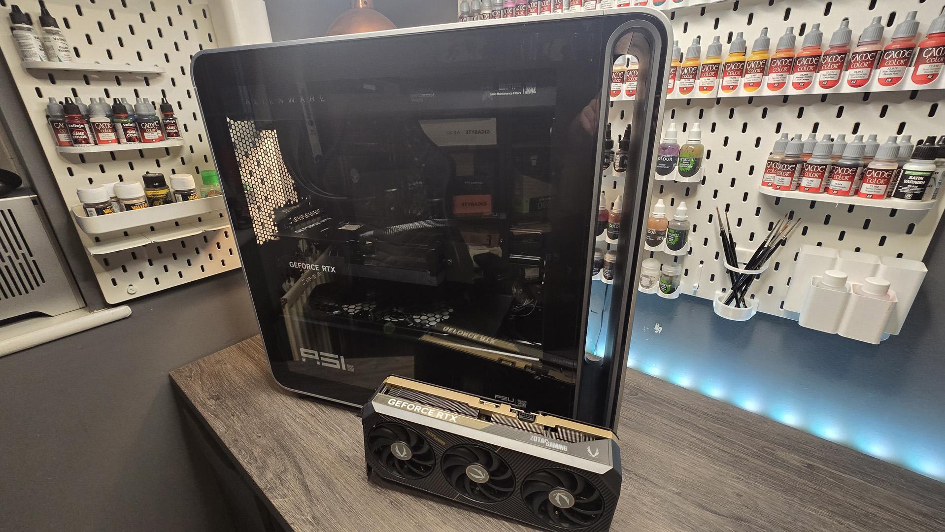 An Alienware Area-51 (2025) on a desk with a triple-slot GPU next to it to show scale
