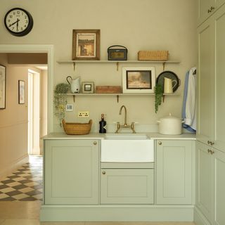 pale green utility room and boot room with Belfast sink