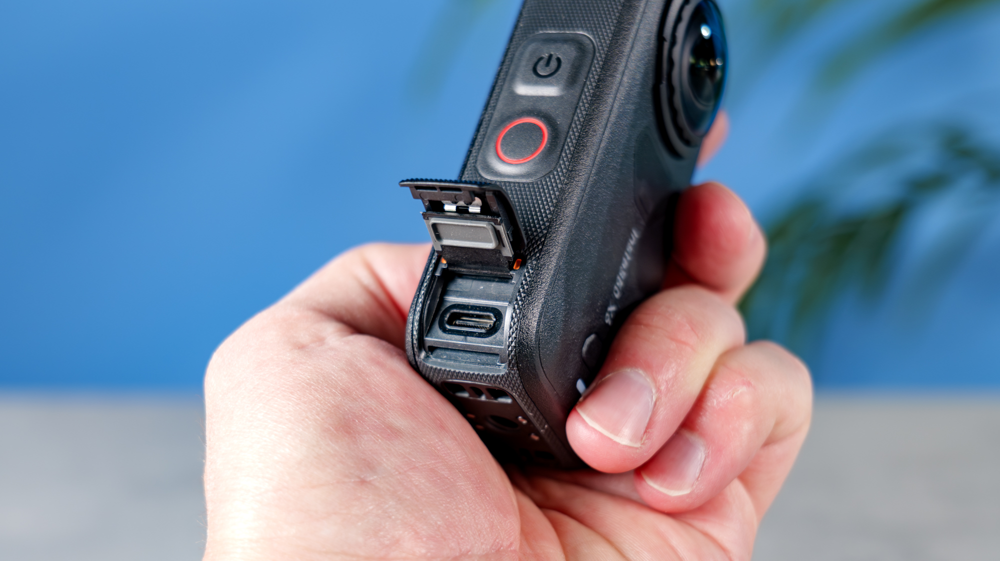 A photo of the Insta360 X6 in hand with the USB-C port showing