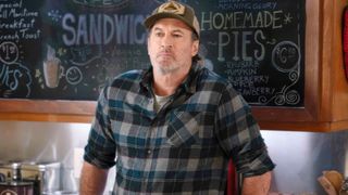 Scott Patterson leans against a cafe counter