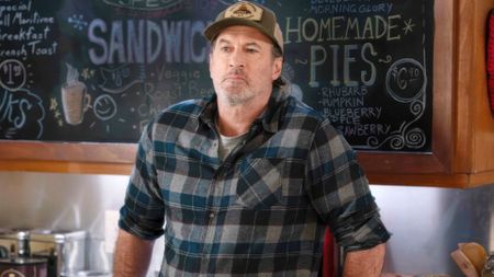 Scott Patterson leans against a cafe counter