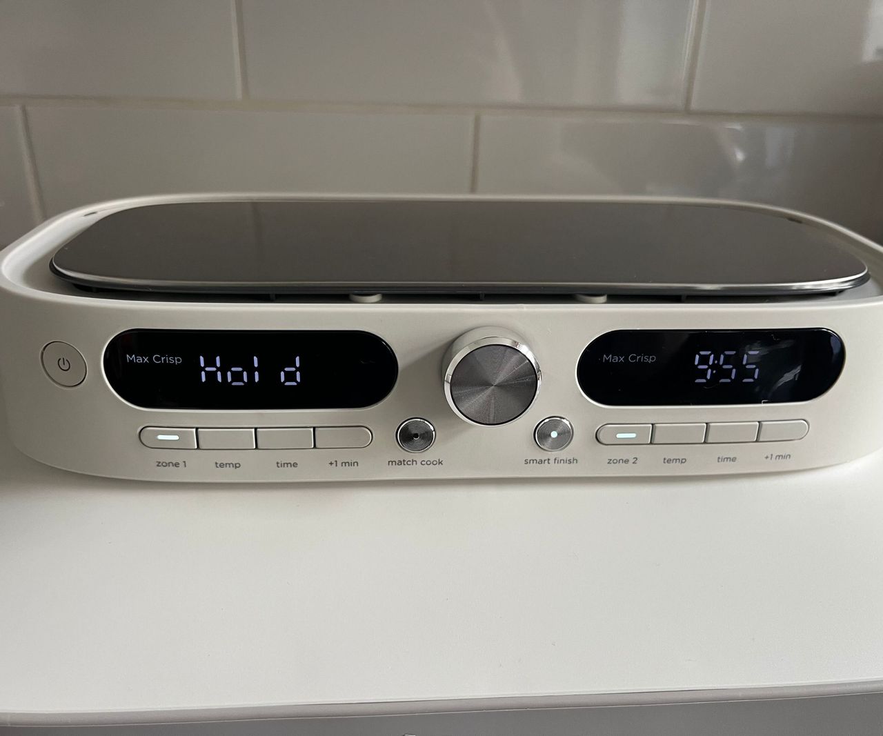 The control panel for the Ninja Crispi DualZone with one timer counting down, and one side on Hold.