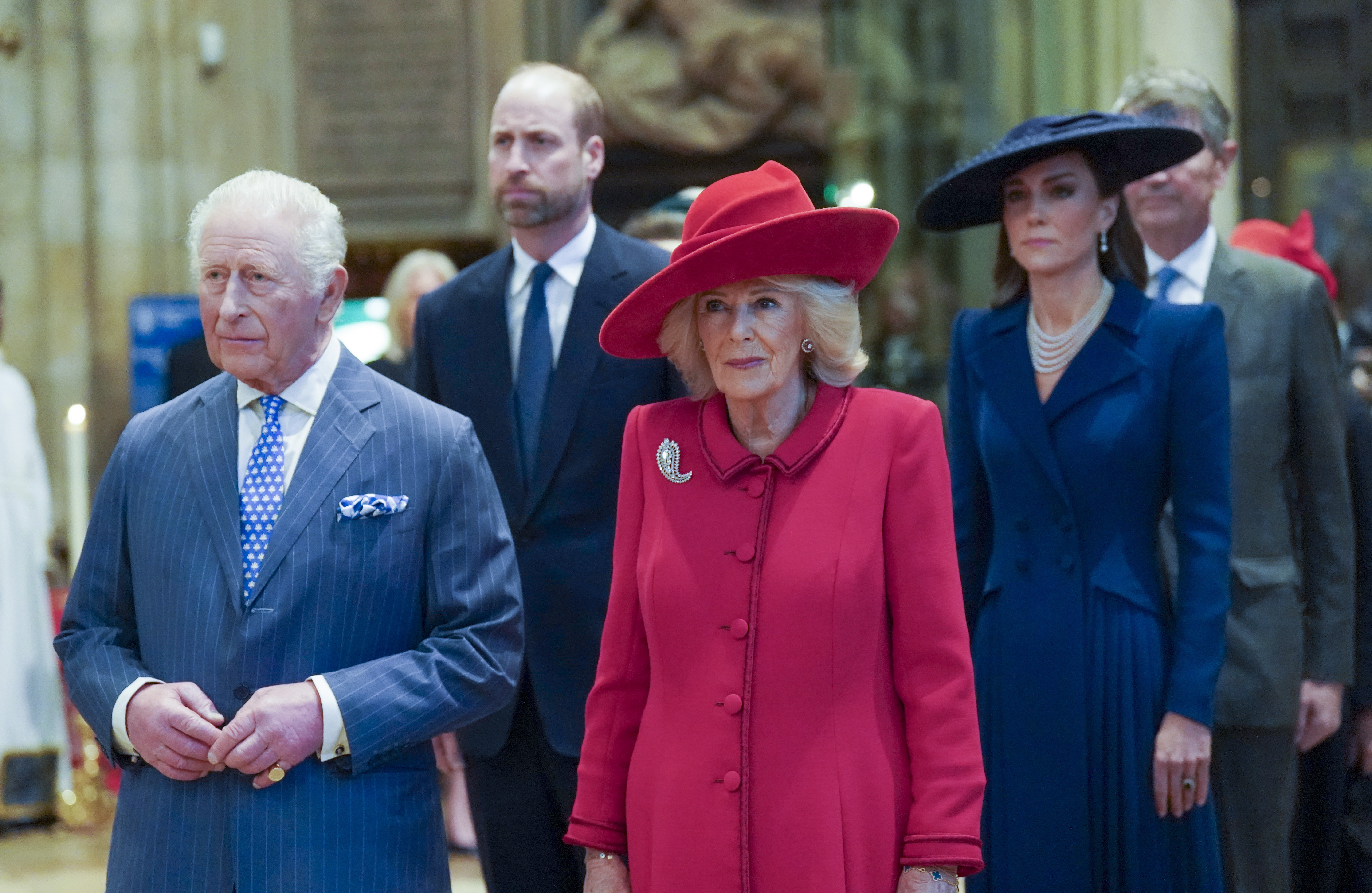 King Charles and Queen Camilla standing in front of Prince William and Princess Kate