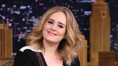 Adele smiling at a talk show.