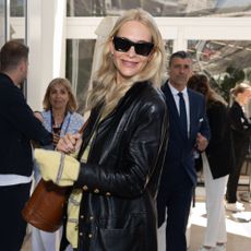 Poppy Delevingne wears white trainers with straight-leg jeans and a leather jacket in Cannes.