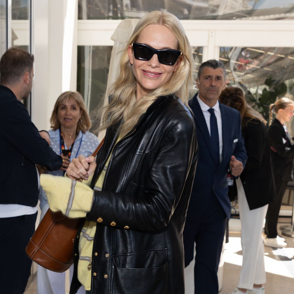 Poppy Delevingne wears white trainers with straight-leg jeans and a leather jacket in Cannes.