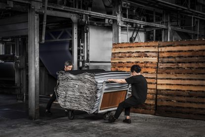Two men in factory wheeling a roll of Loro Piana Denim Silk