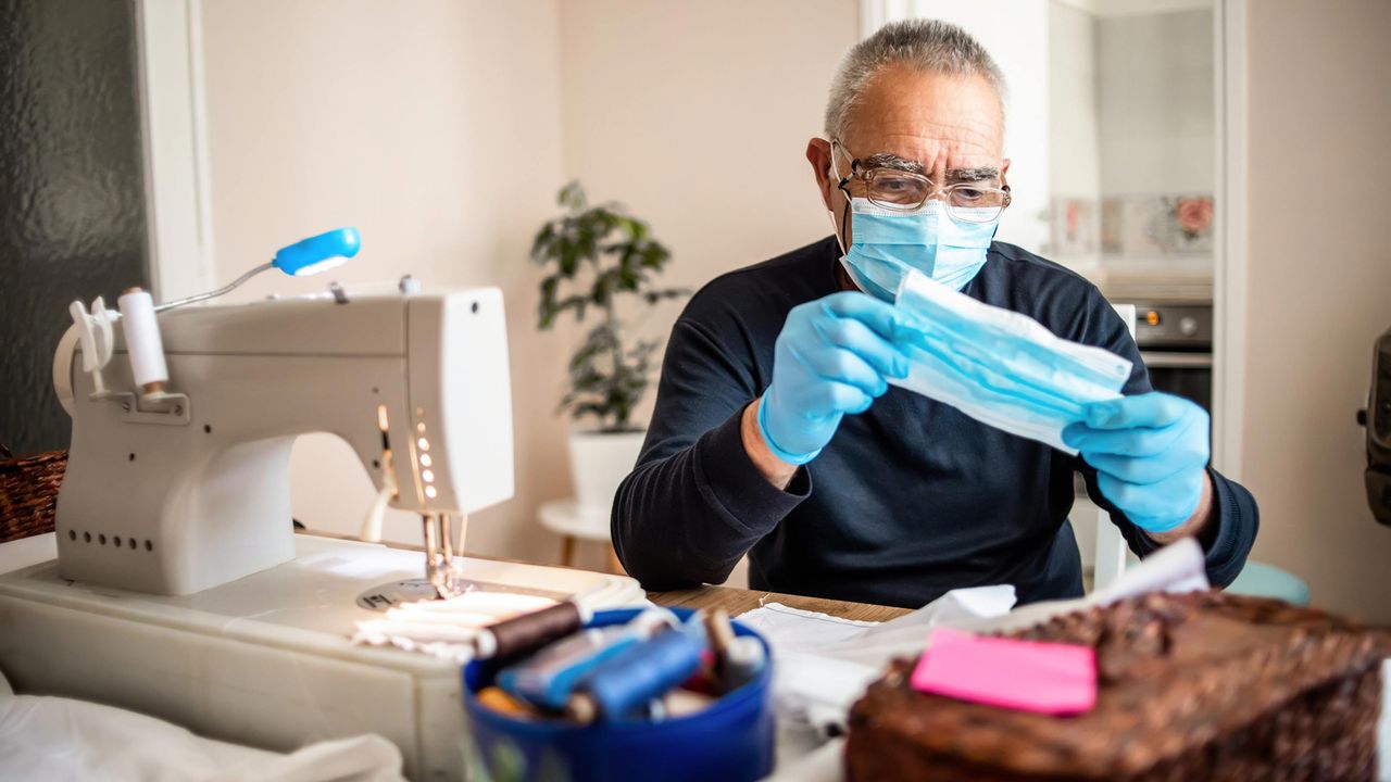 Senior volunteer sewing COVID face masks