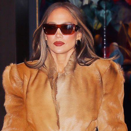 05/13/2026 Jennifer Lopez in New York City wearing a waist length fur coat paired with a long rust colored skirt paired with brown heels and a dark brown crocodile leather clutch.