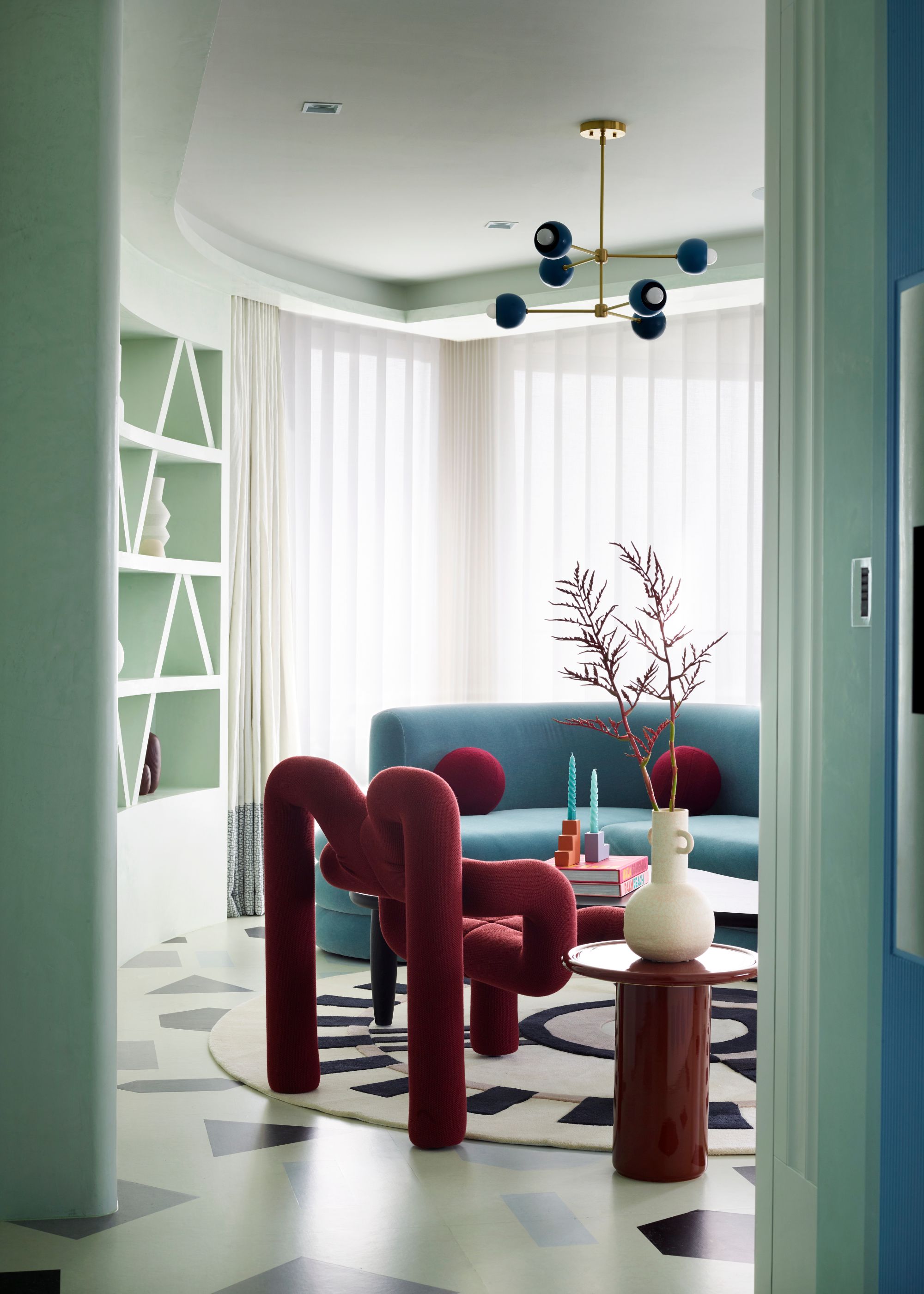 modern living room with bold sculptural furniture and glass doors with sheer curtains