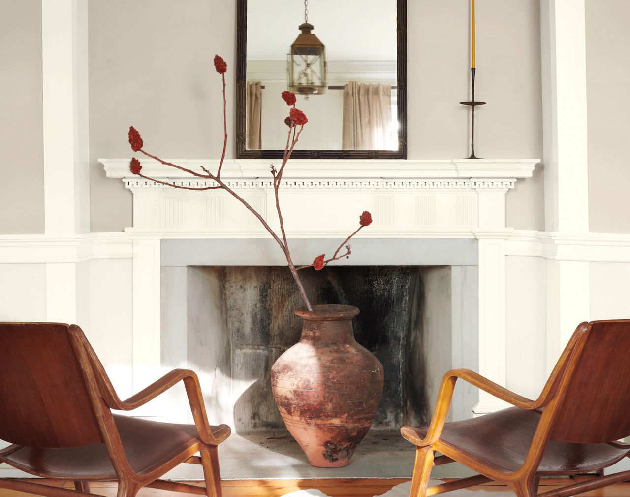 A living room with grey walls and white trim plus two leather armchairs