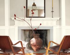 A living room with grey walls and white trim plus two leather armchairs