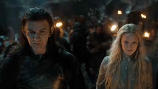 From left to right: Adar and Galadriel standing together with lots of people behind them.