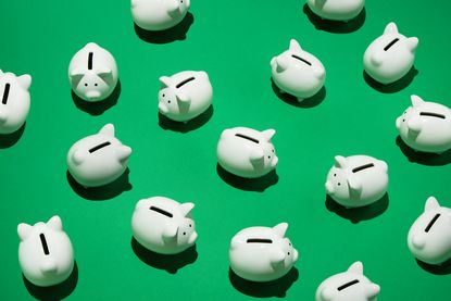 16 small white piggy banks placed randomly on green surface