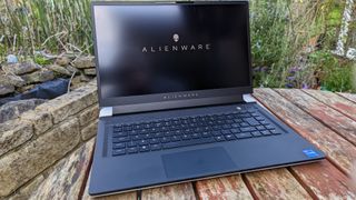 An Alienware X15 R2 gaming laptop on a wooden table