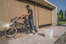 Man cleaning bike with Worx Hydroshot WG629E.1 pressure washer