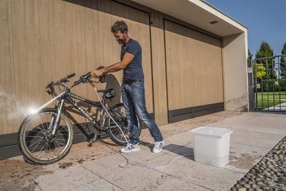 Man cleaning bike with Worx Hydroshot WG629E.1 pressure washer