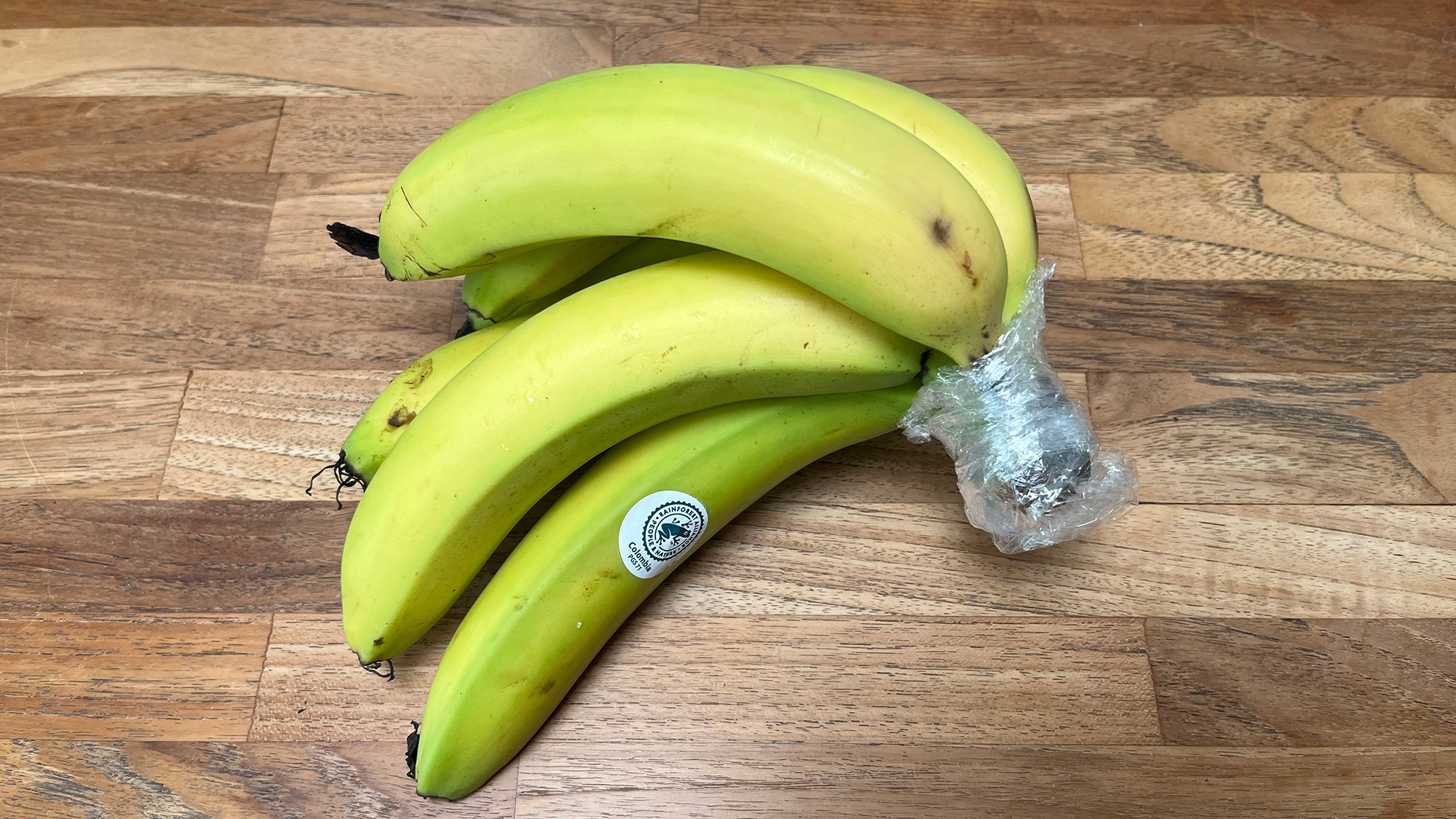Bananas with cling film on stem