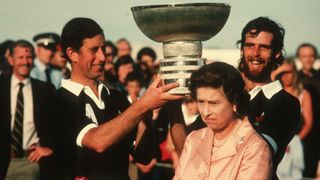 Queen Elizabeth II makes a funny face as Prince Charles holds a trophy above her head following a polo match at Windsor Great Park on July 01, 1984 in Windsor, England.