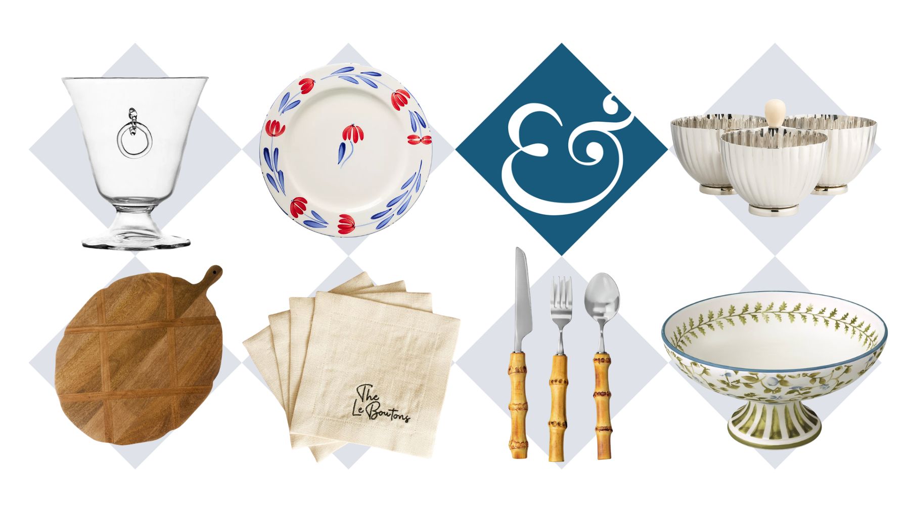 Assorted tableware, including a water tumbler, wooden serving board, ceramic dinner plate, linen napkin set, bamboo flatware, nut server, and pedestal bowl, pictured against a white background
