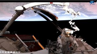 an astronaut in a white spacesuit works outside a space station with earth in the background