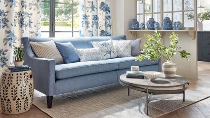 blue sofa in living space with coffee table and blue vases