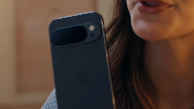A woman holding up a phone, with a view of the back of the handset