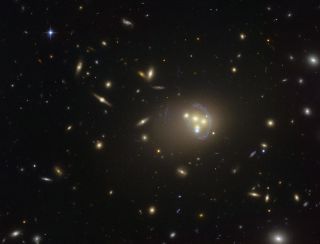 A Hubble Space Telescope image of galaxy cluster Abell 3827, where dark matter may have been observed interacting with itself during a galaxy collision.