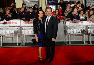 Former Manchester United and England footballer Gary Neville (R) and his wife Emma pose for pictures as they arrive at the world premiere of the documentary 'The Class of 92' in London's Leicester Square, on December 1, 2013. AFP PHOTO / LEON NEAL (Photo credit should read LEON NEAL/AFP via Getty Images)