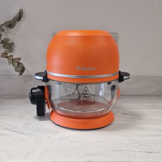 Orange halogen oven on a white kitchen counter