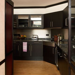 kitchen with wooden floor and black cabinets