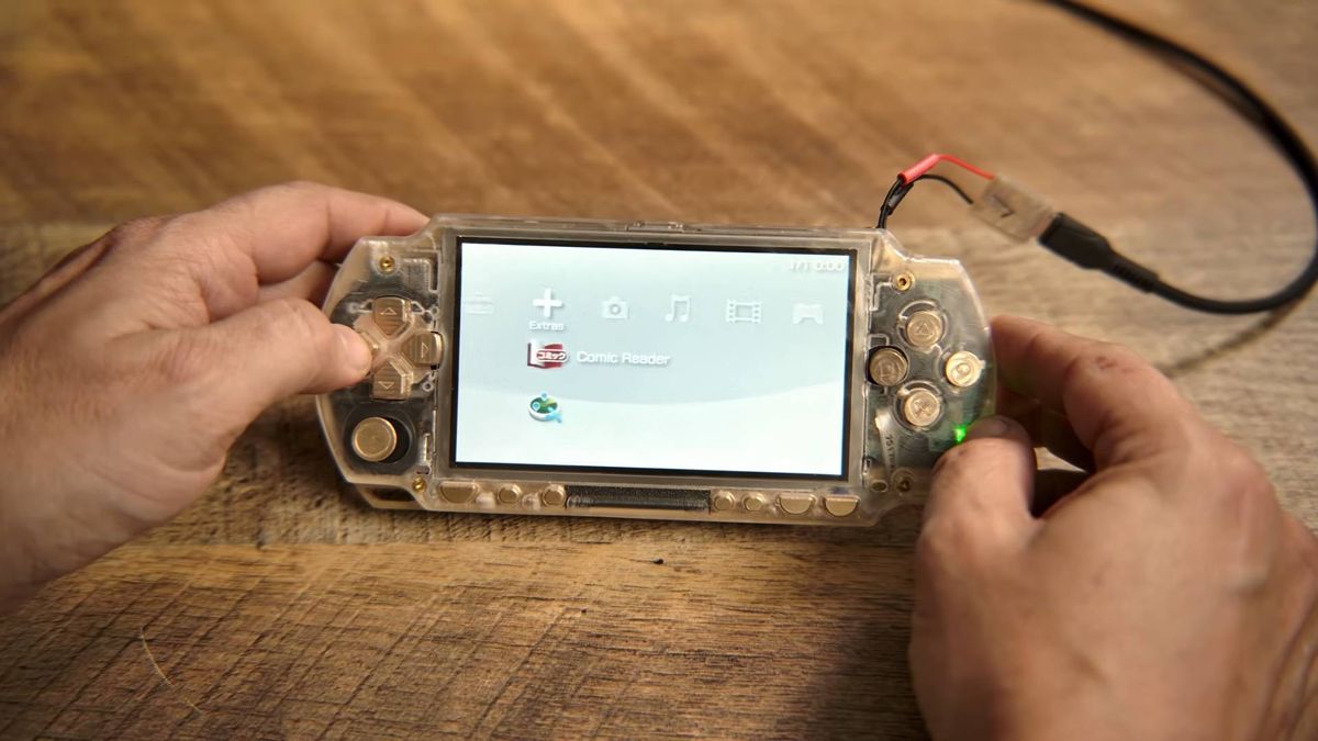 Brass and acrylic PSP with power connected and XrossMediaBar displayed.