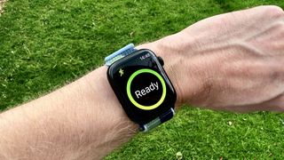 Apple Watch 7 ranteessa vihreää nurmikkoa vasten ja valmiina treeniseurantaan