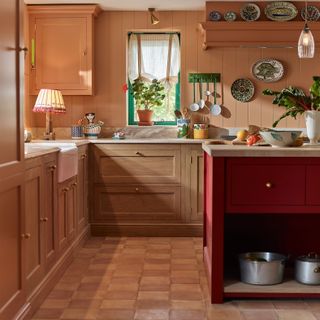 Italian inspired kitchen with pink walls, wooden cabinets and red island