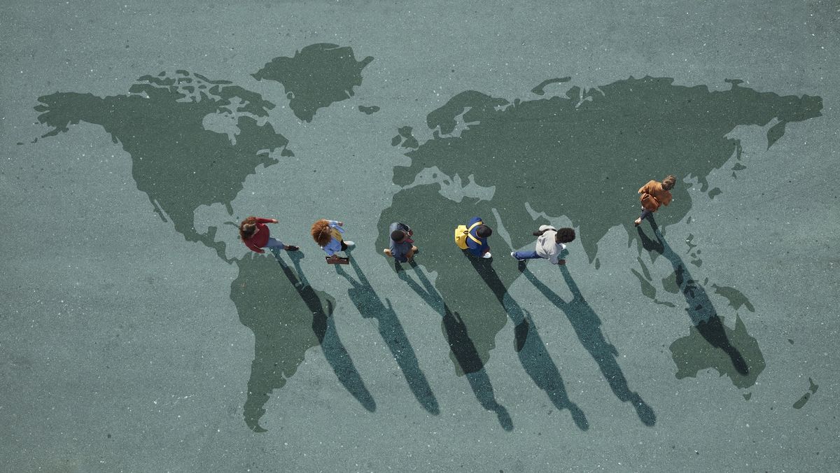 Bird&#039;s eye view of people walking on a map of the world.