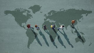 Bird's eye view of people walking on a map of the world.