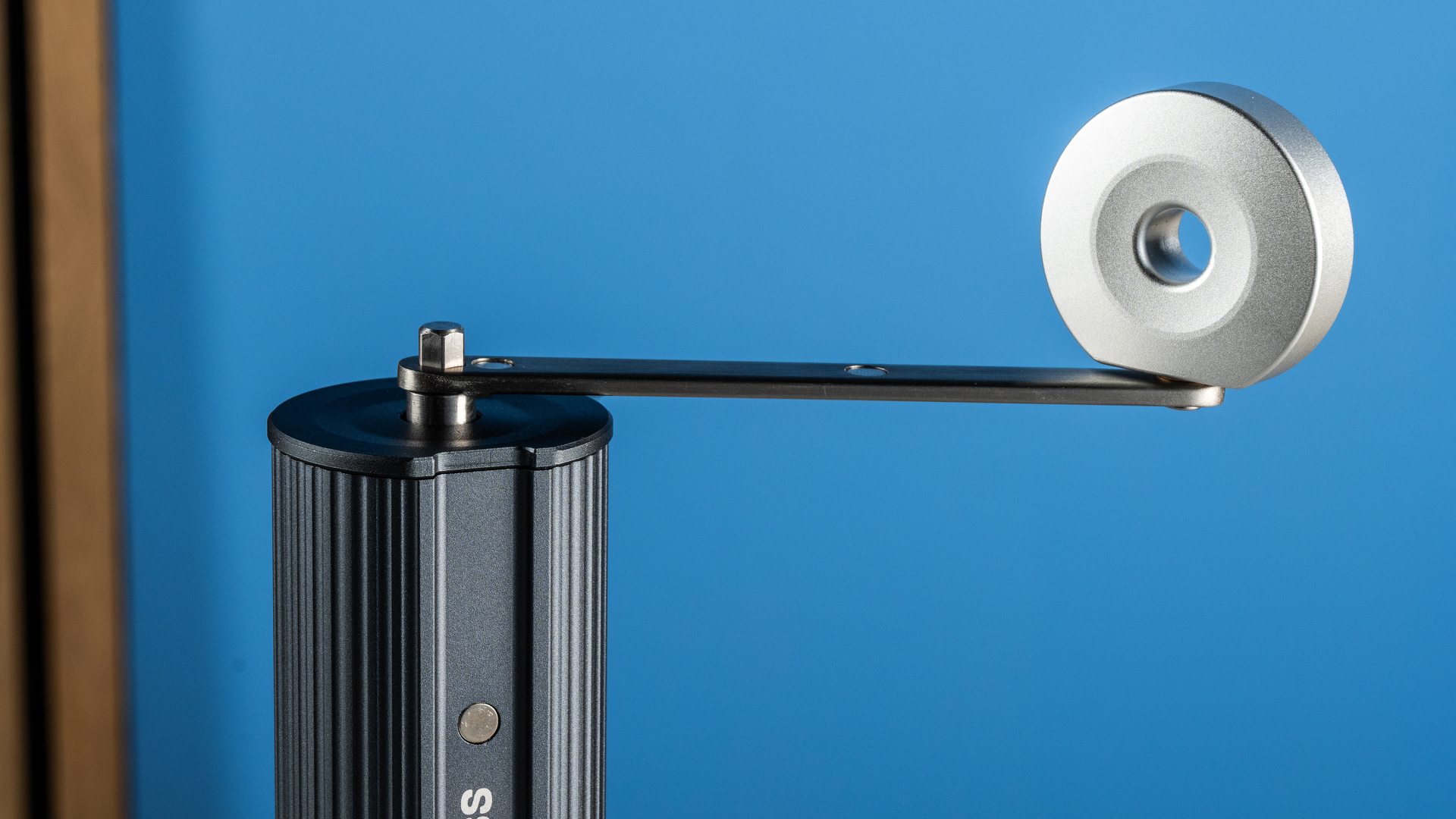 the aeropress manual coffee grinder in gray and silver against the tom's guide blue background