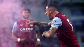 Danny Ings celebrates scoring for Aston Villa against Brighton as a flare is thrown onto the pitch.