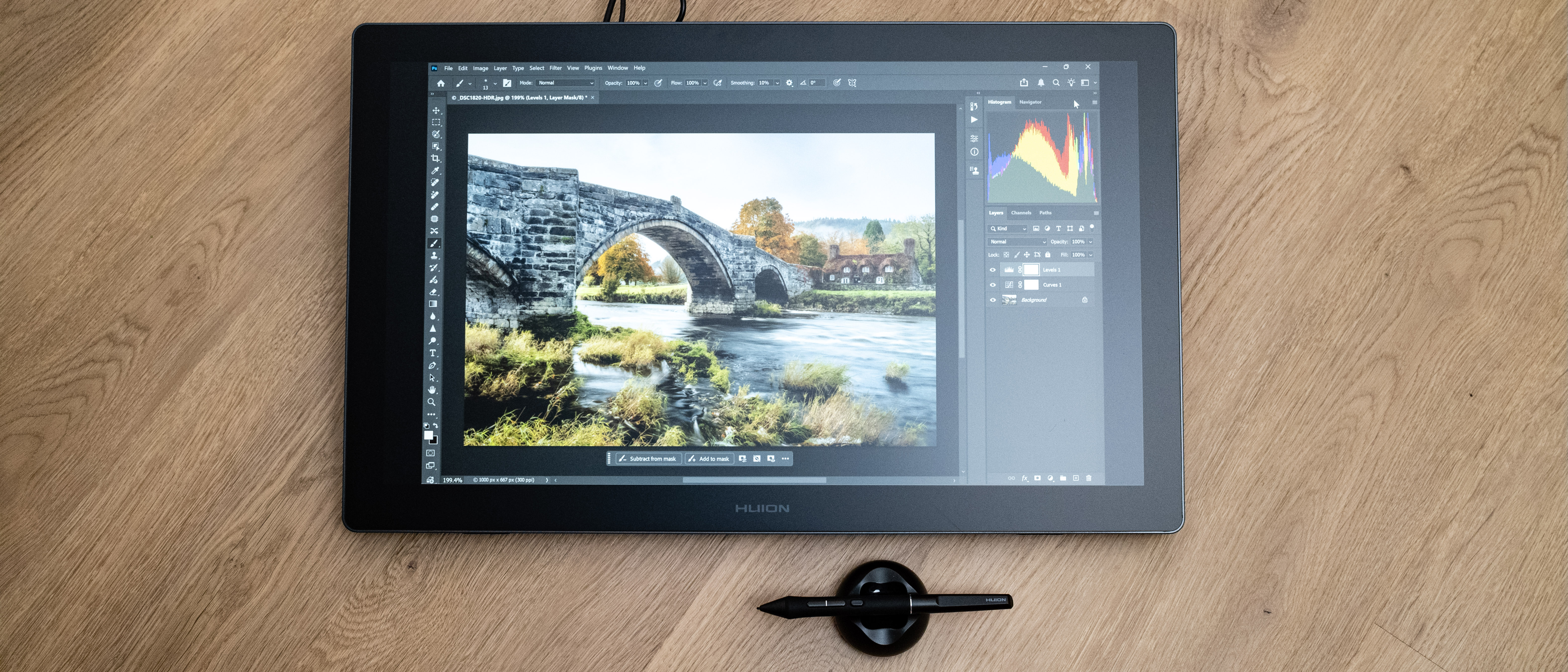 Huion Kamvas 22 Gen 3  and pen on a wooden floor