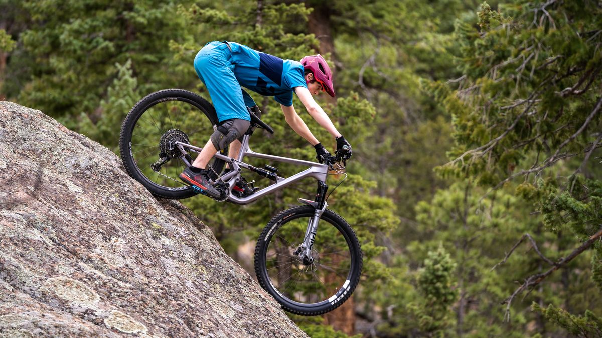 A mountain biker riding down a large rock face