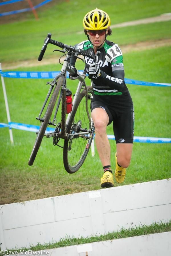 Mary McConneloug (Kenda-Seven-NoTubes) lifiting her bike over the barriers