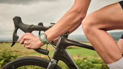 Image shows a cyclist using one of the best smartwatches for cycling