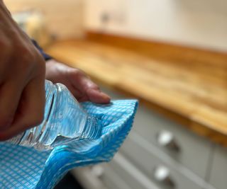 applying white spirits to blue cleaning cloth