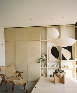 Neutral living room with contemporary wall art and storage display, and Scandi-style chair with cane