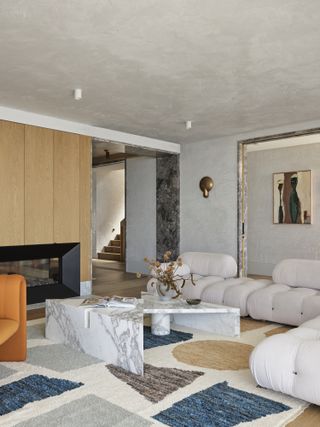 A living room with an organic-shaped coffee table in marble