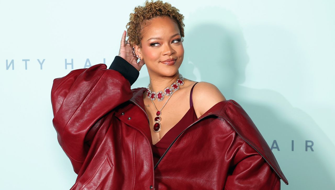 Rihanna wears an extra oversize bomber jacket in front of a step and repeat