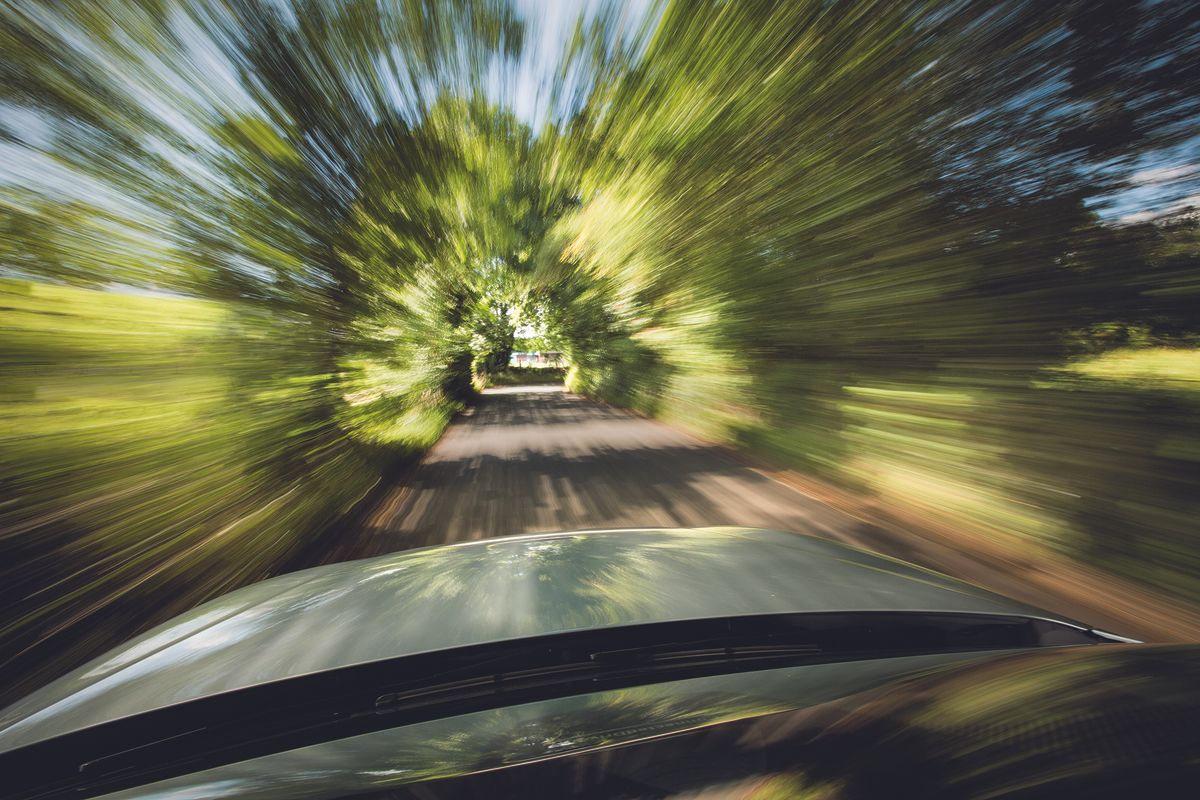 blurry trees alongside a road