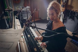 Raye playing a piano