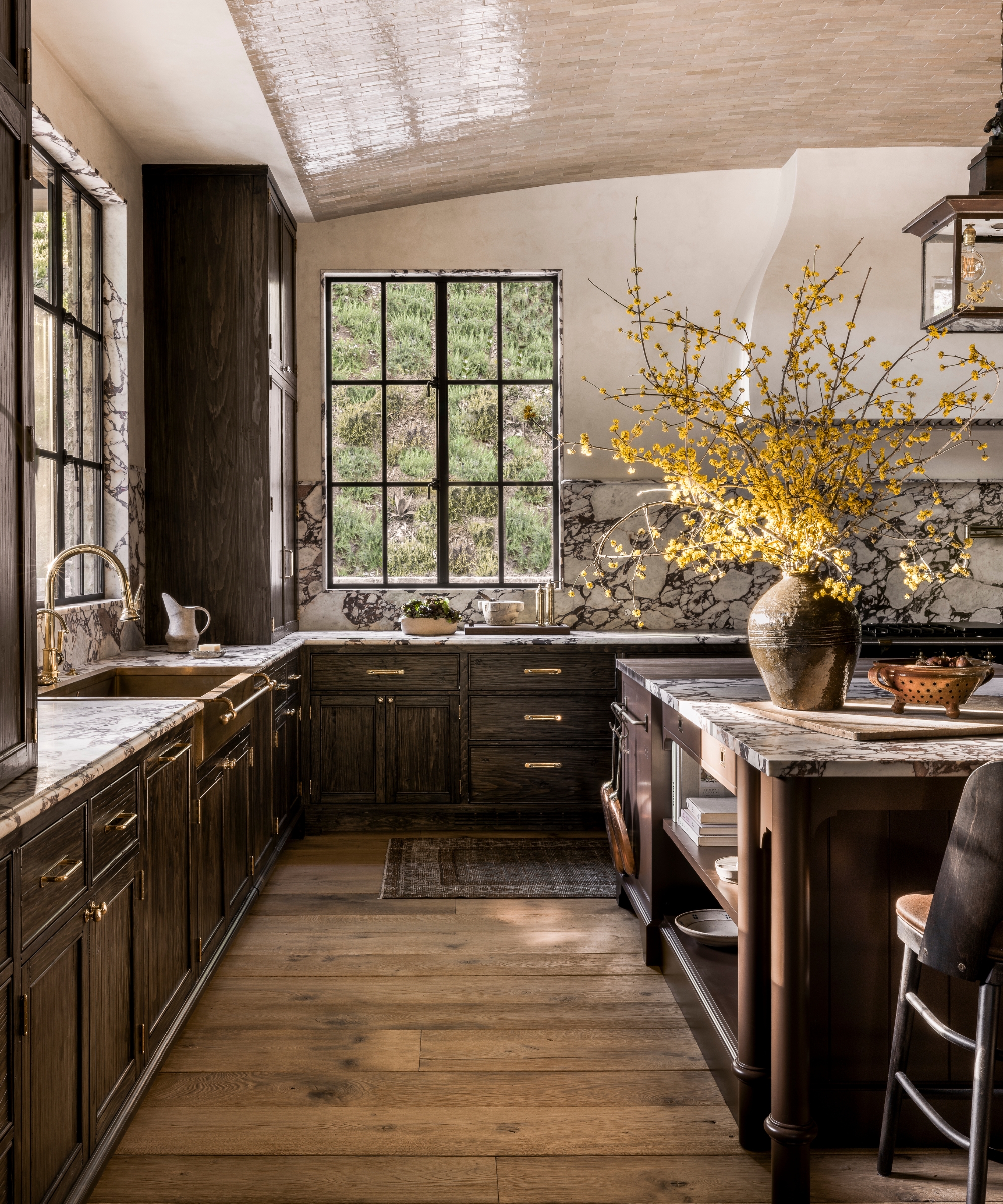 A dark wood kitchen with marble countertops and fall decor